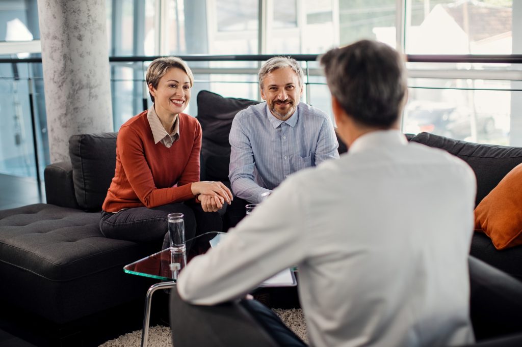 Happy couple having a meeting with financial advisor in the office.