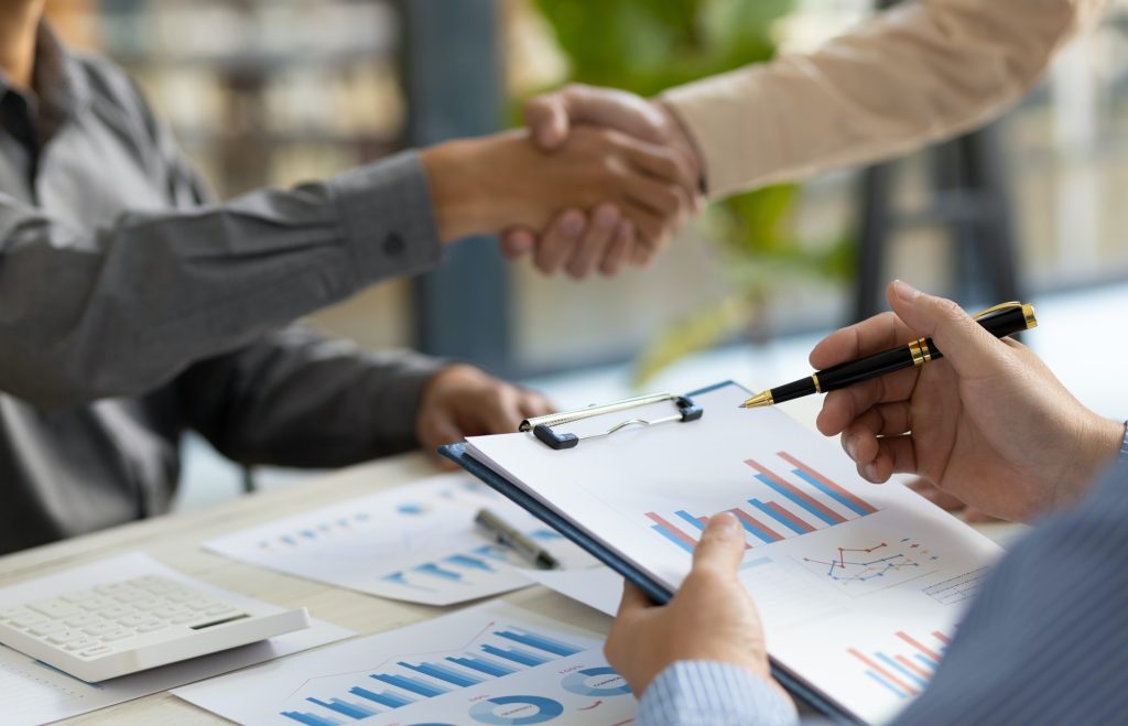 Meeting of business people, financial advisors shaking hands.